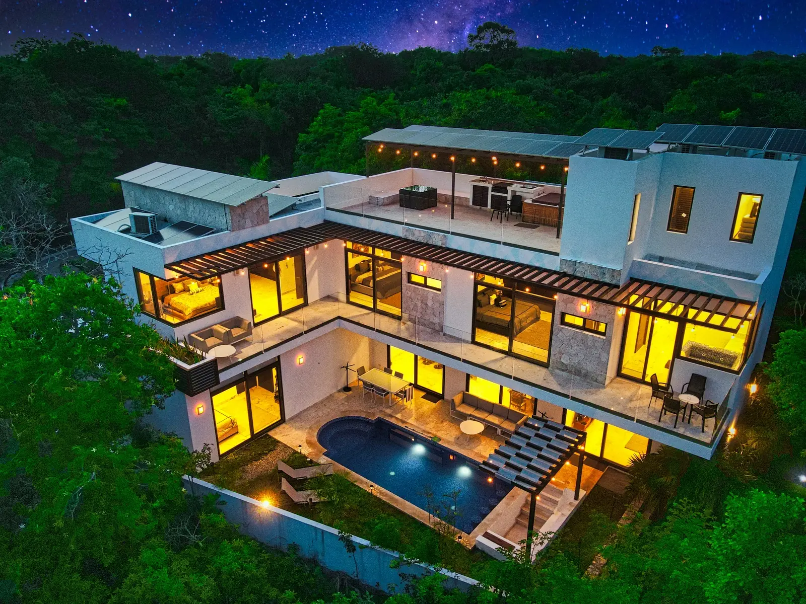 Casa Estrellas iluminada de noche, vista aérea sobre la selva maya